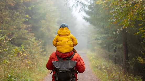 Image of father and son walking in the autumn forest